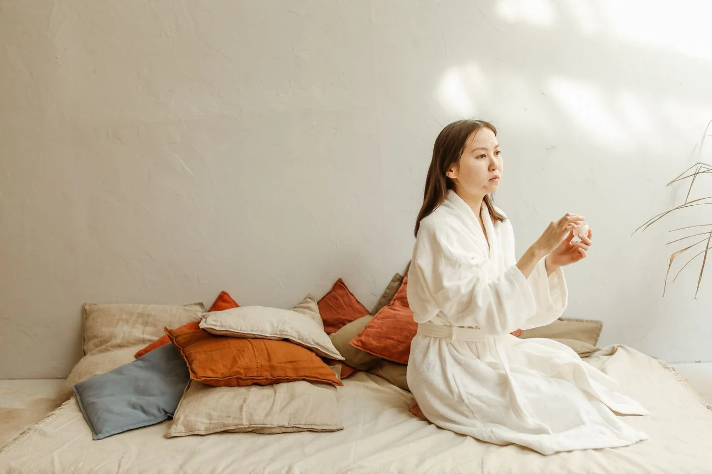 A woman holding a skincare bottle during her daily routine