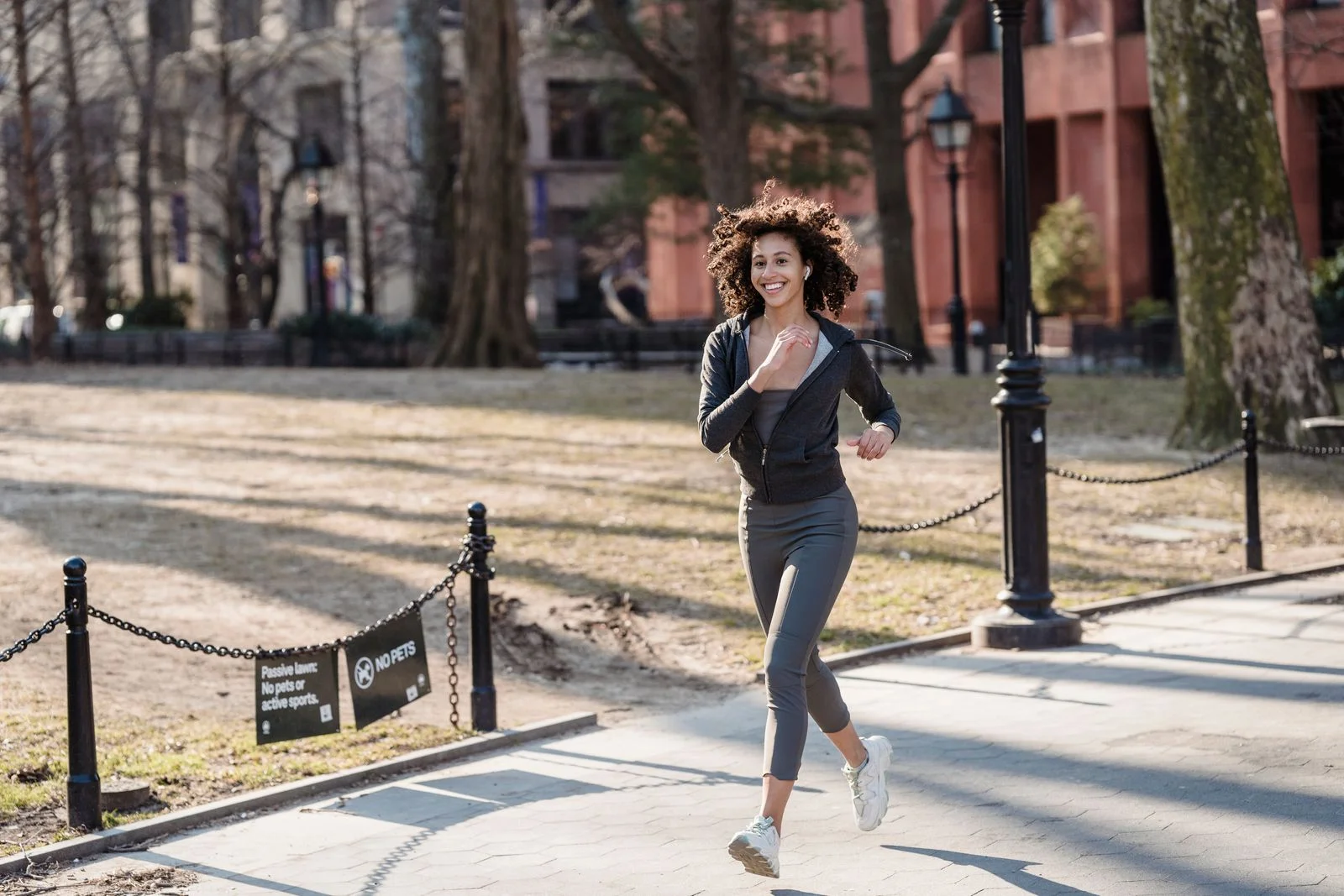 A Black woman enjoying a run outdoors in an urban park